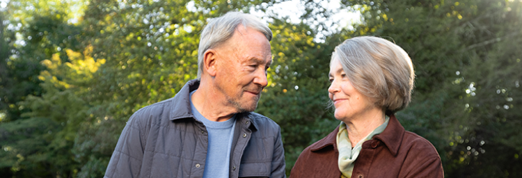 An elderly couple outside looking at each other lovingly. Actor portrayal