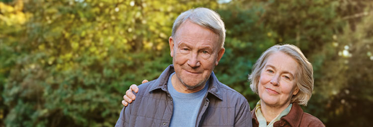 A male patient and his wife walking outside. Actor portrayal